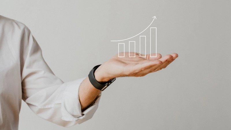 Gráfico de barras digital en aumento con superposición de la mano de un empresario